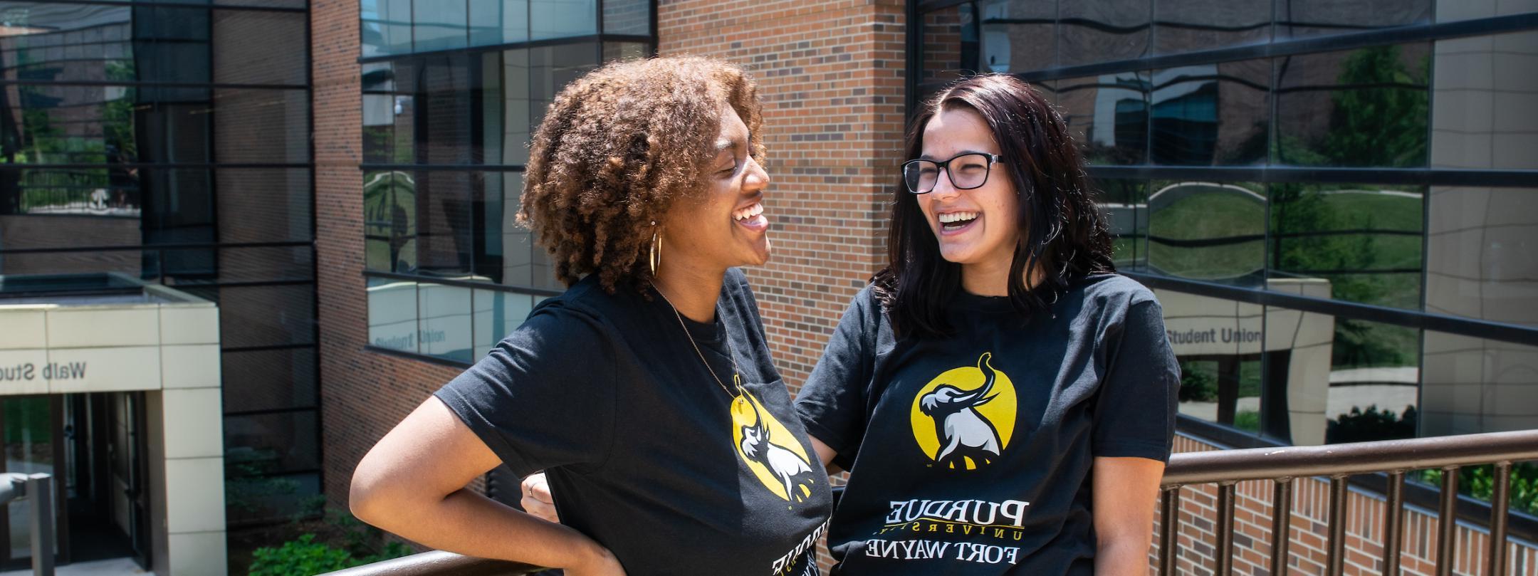 Two transfer students stand outside wearing PFW Transfer shirts.